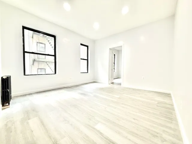 an empty room with windows and closet
