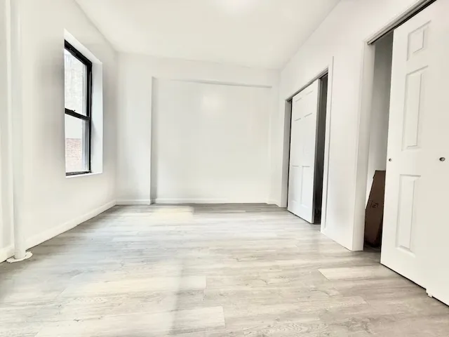 an empty room with windows and closet