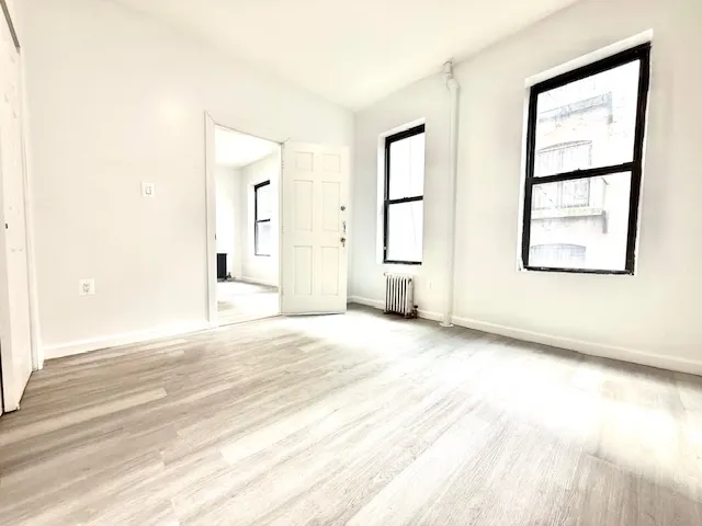 an empty room with windows and closet