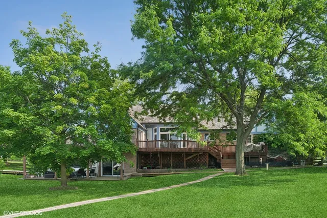 an aerial view of a residential houses with outdoor space and trees