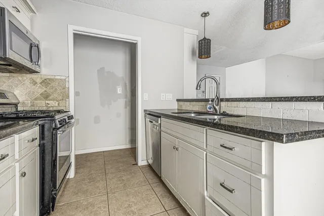 a kitchen with granite countertop a sink and a stove