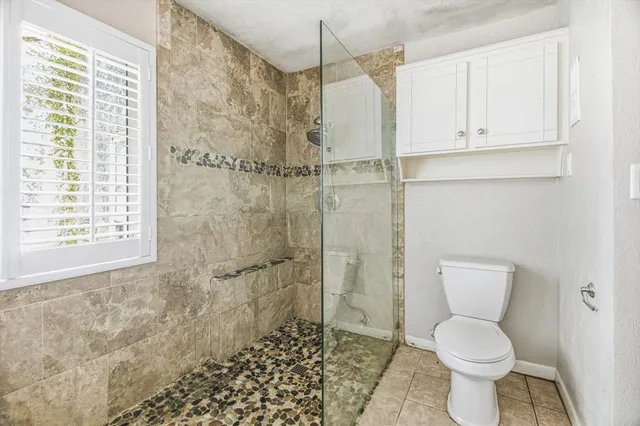 a bathroom with a toilet and a shower