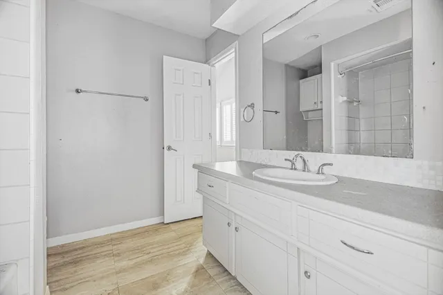 a bathroom with a granite countertop sink and a mirror