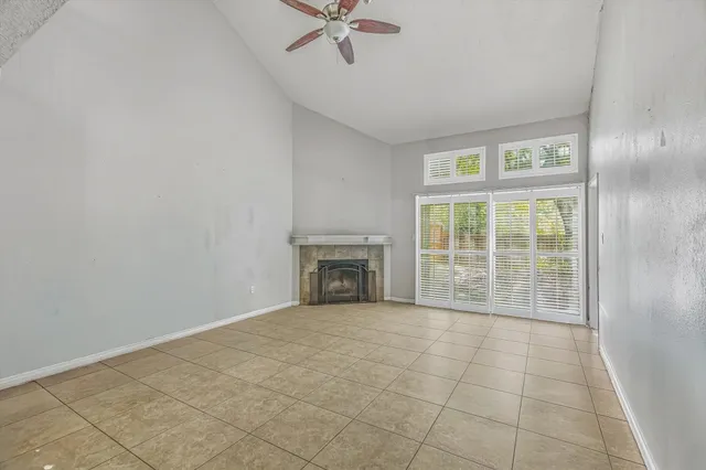 a view of an empty room with a fireplace and a window