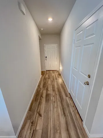 a view of a hallway with wooden floor