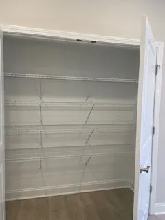 a view of walk in closet with empty racks