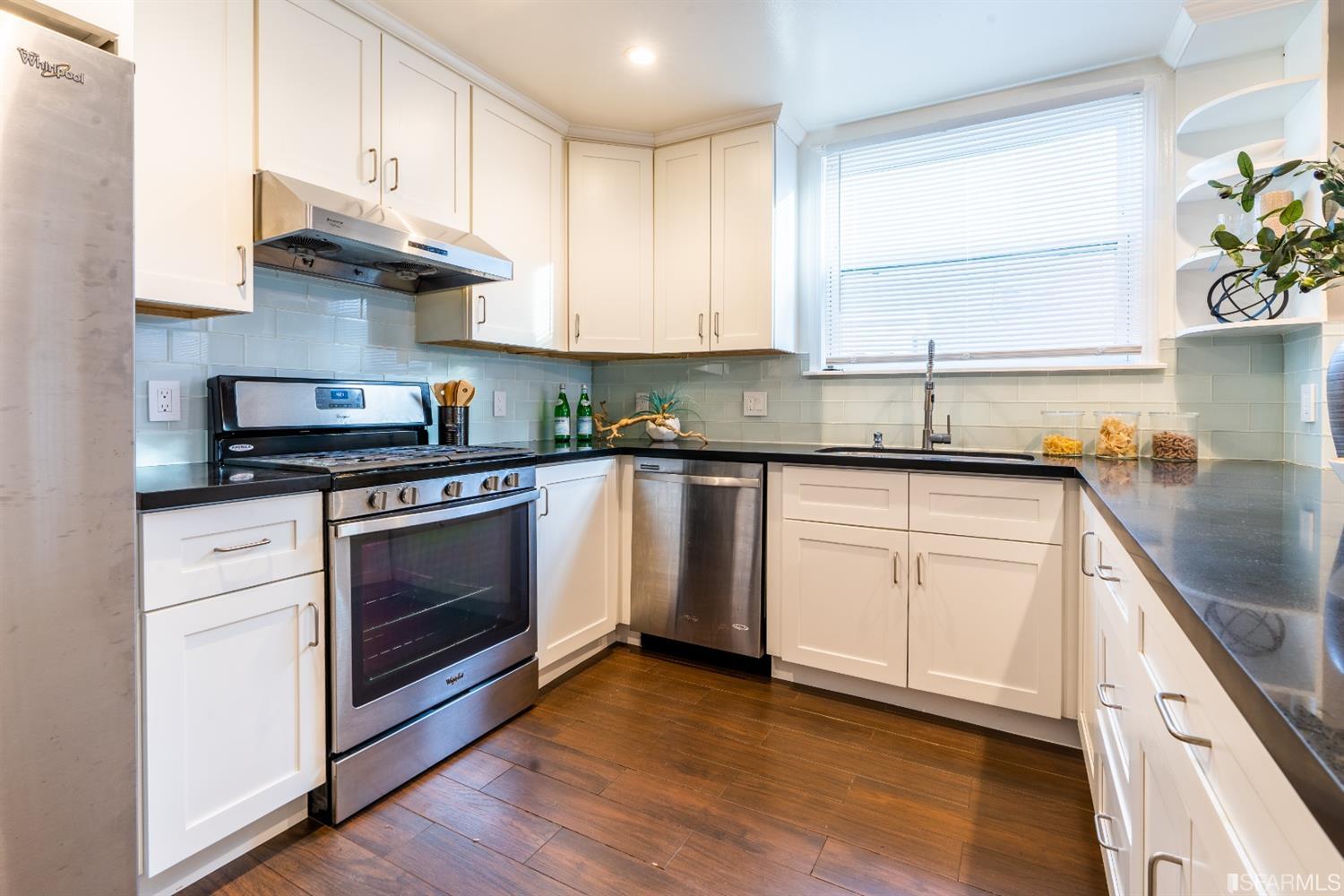 53 Wavecrest Drive Daly City, CA 94015 - Photo 11 of 24 a kitchen with stainless steel appliances granite countertop a sink a stove a refrigerator and white cabinets