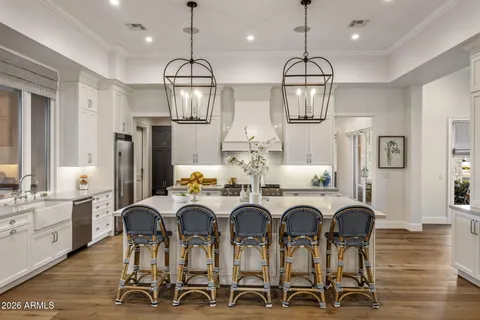 a large white kitchen with lots of counter space and stainless steel appliances