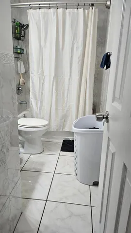 a bathroom with a toilet and a shower