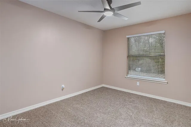 an empty room with a window and a fan