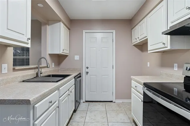 a kitchen with granite countertop a sink stove and cabinets