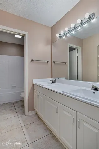 a bathroom with a double vanity sink and a mirror