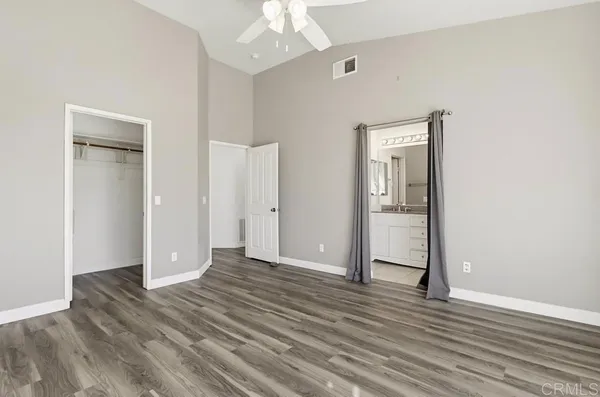 an empty room with wooden floor and mirror
