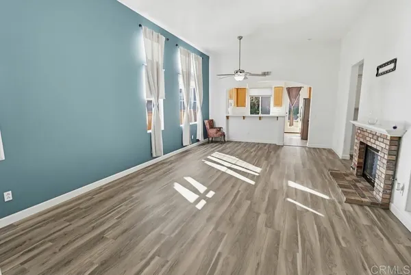 a view of a livingroom with wooden floor and a kitchen space