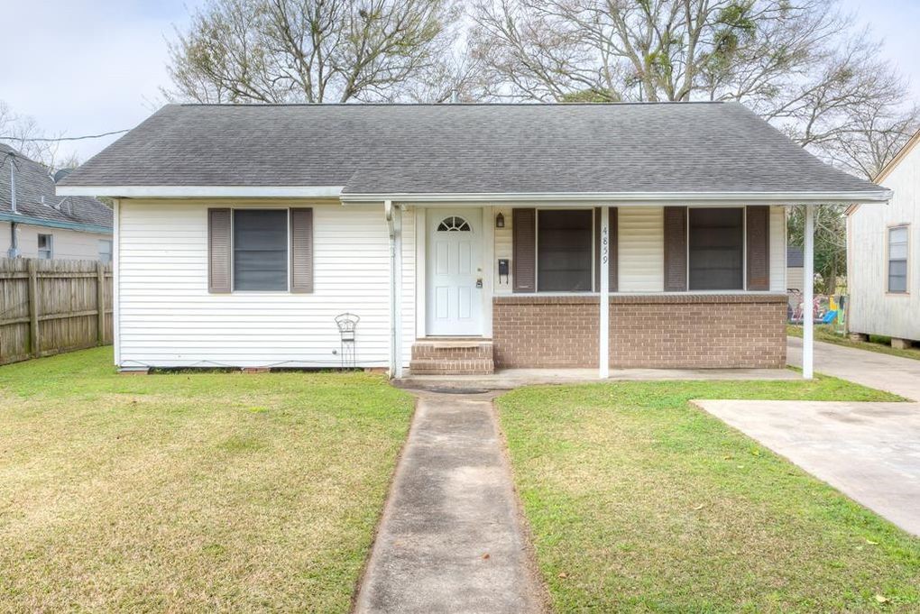 4859 Harrison Avenue Groves, TX 77619 - Photo 1 of 14 a front view of a house with garden