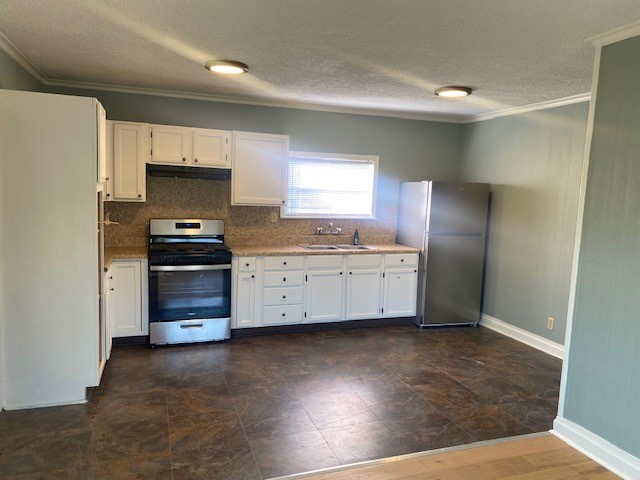 4859 Harrison Avenue Groves, TX 77619 - Photo 12 of 14 a kitchen with stainless steel appliances a refrigerator and a stove top oven