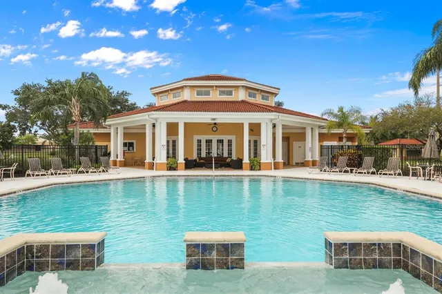 a view of a house with a swimming pool and a yard