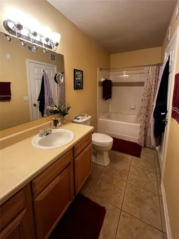 a bathroom with a sink a toilet a mirror and shower