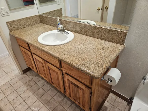 a bathroom with a granite countertop sink and a mirror