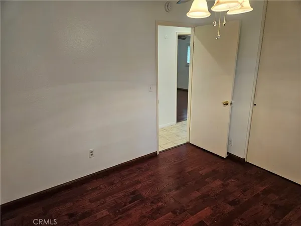 an empty room with wooden floor and mirror