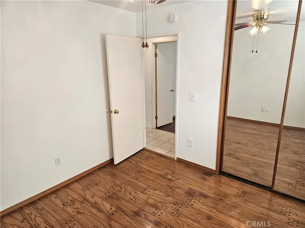 an empty room with wooden floor and cabinet