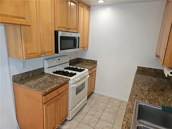 a kitchen with stainless steel appliances granite countertop a sink stove and microwave