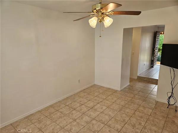 an empty room with wooden floor fan and window
