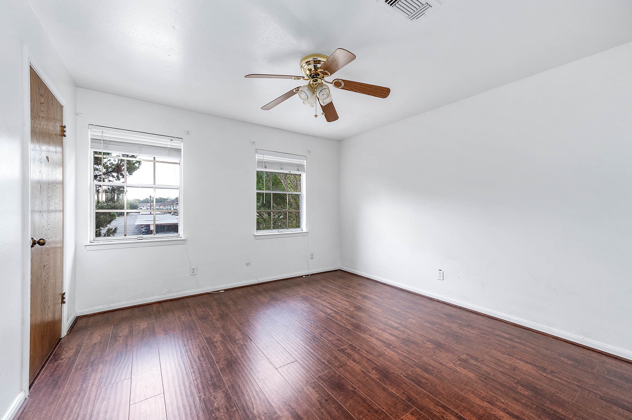 1609 Mapleton Drive Houston, TX 77043 - Photo 17 of 21 an empty room with wooden floor chandelier fan and windows