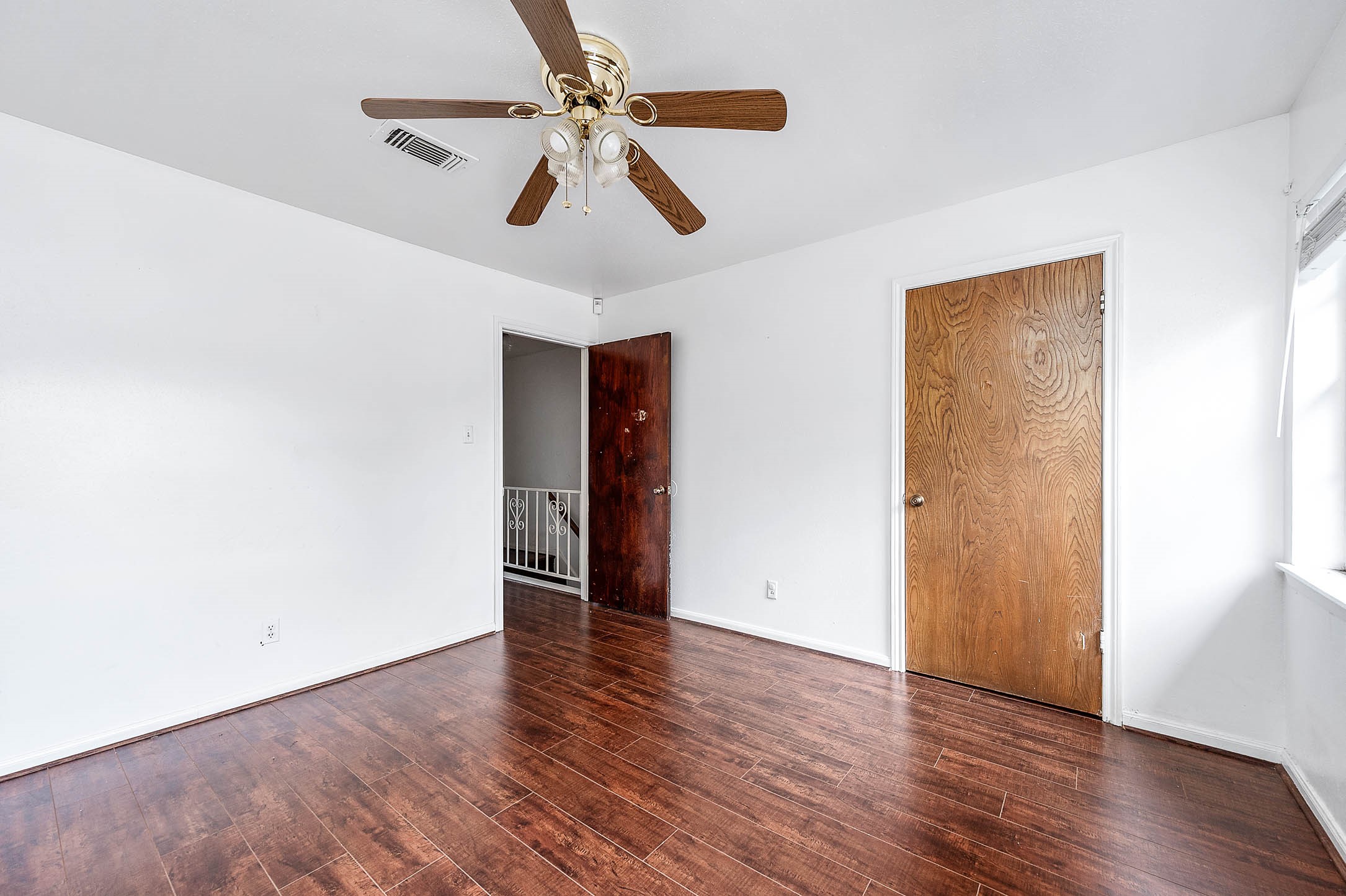 1609 Mapleton Drive Houston, TX 77043 - Photo 18 of 21 an empty room with wooden floor hallway and a ceiling fan