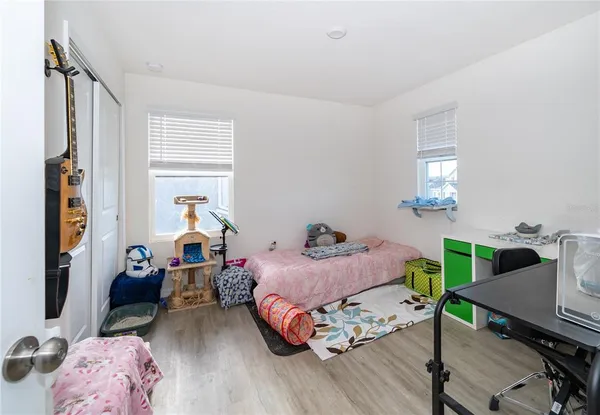 a bedroom with bed and a wooden floor
