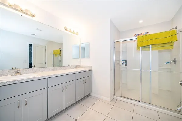 a bathroom with a double vanity sink mirror and shower
