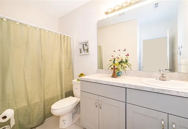 a bathroom with a granite countertop sink a toilet and a mirror