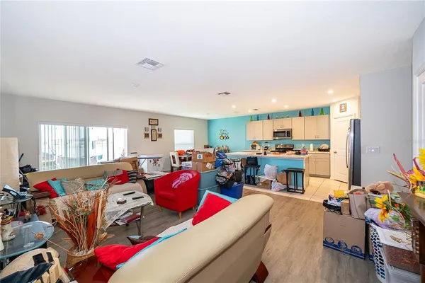 a living room with lots of furniture and a dining table with kitchen view