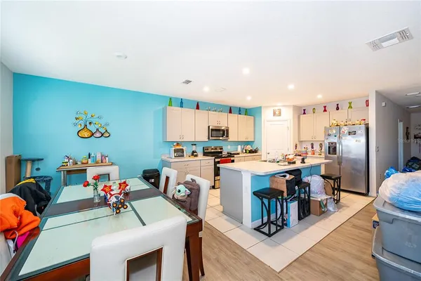a view of a dining hall with furniture and a kitchen view