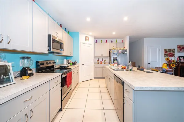 a kitchen with stainless steel appliances kitchen island granite countertop a sink and cabinets
