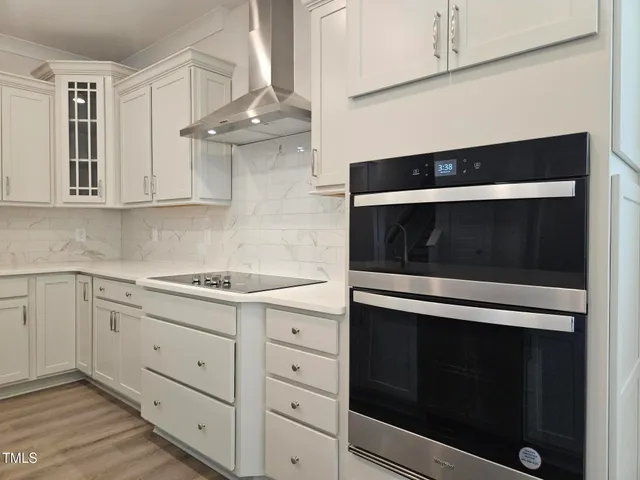 a kitchen with granite countertop white cabinets appliances and a sink