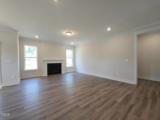 an empty room with wooden floor and fireplace