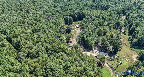 an aerial view of residential house with outdoor space and trees all around