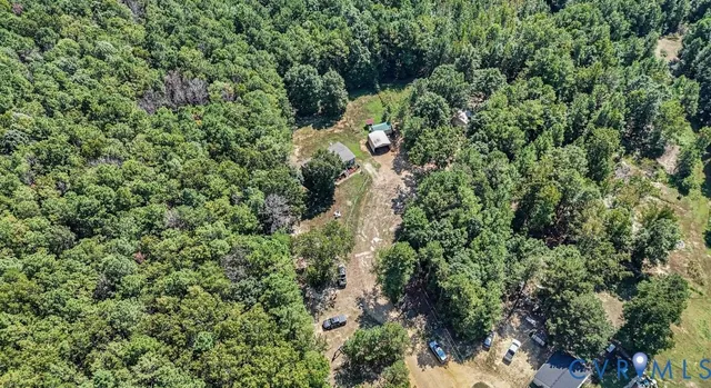 an aerial view of residential house with outdoor space and trees all around