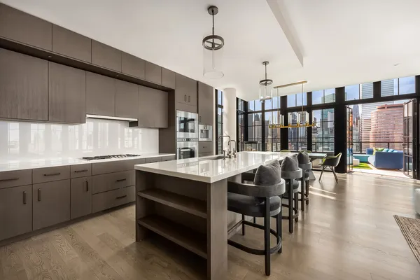 a kitchen with granite countertop a stove a sink a dining table and chairs with wooden floor