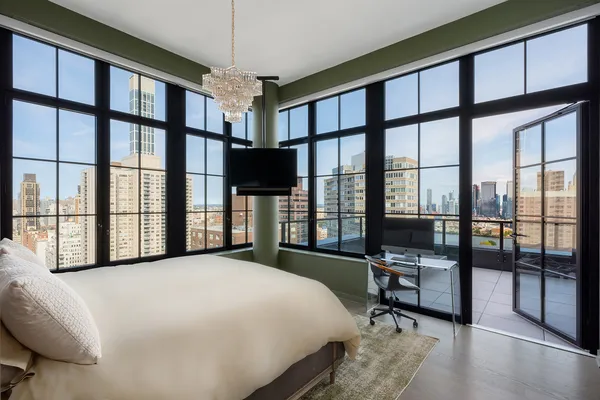 a bedroom with a bed and a large window