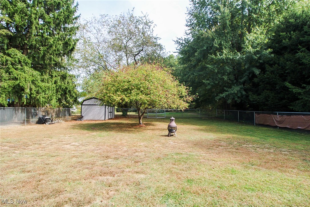 3267 South Leavitt Road Southwest Warren, OH 44481 - Photo 12 of 45 Fenced backyard with a storage shed and view of wooded area