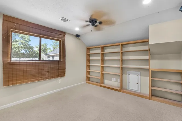 a view of an empty room with a cabinet and a window