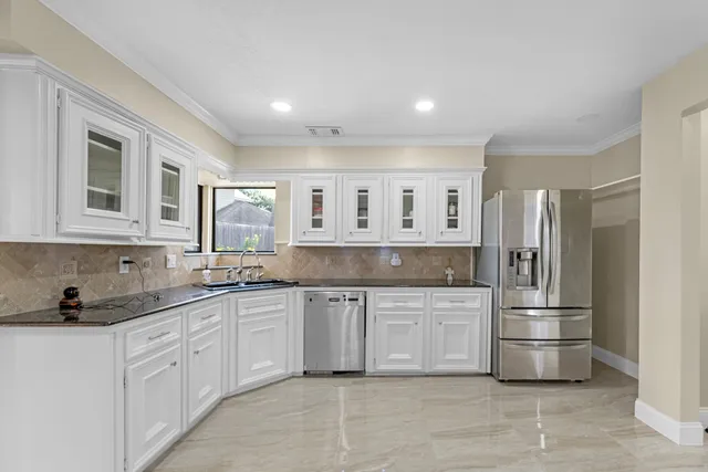 a kitchen with white cabinets and stainless steel appliances