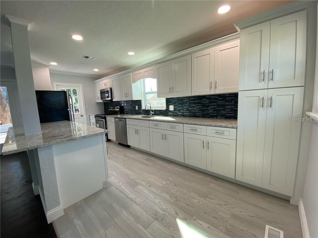 16 Jeff Road Largo, FL 33774 - Photo 5 of 14 a kitchen with stainless steel appliances kitchen island granite countertop a stove and a sink