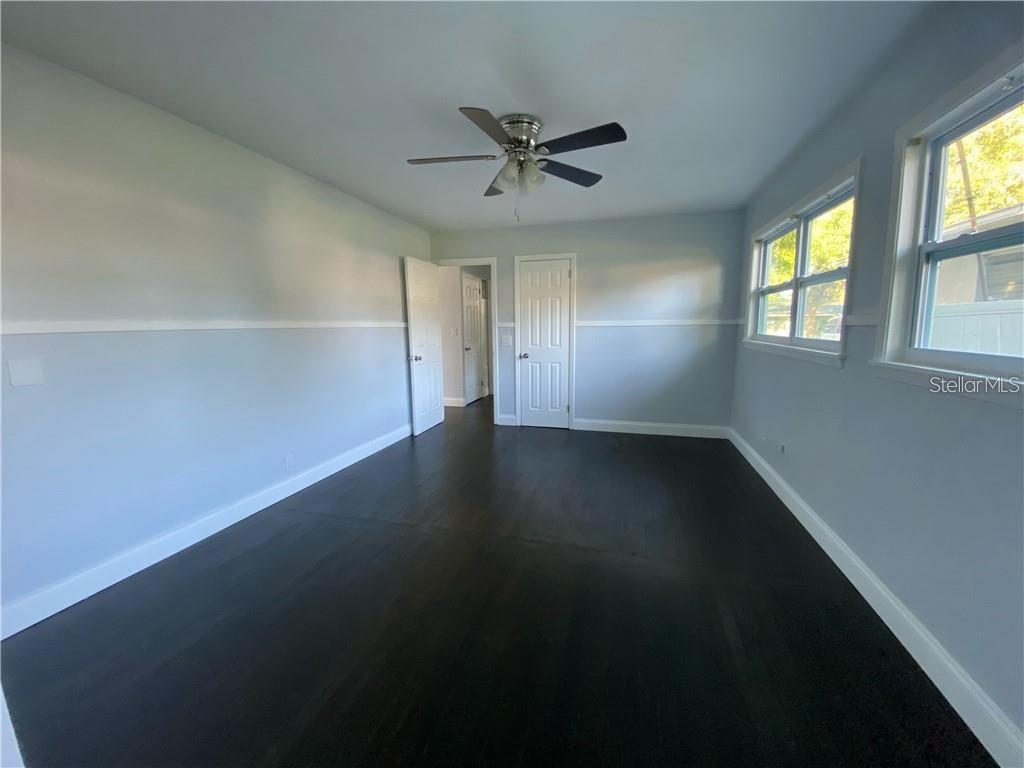 16 Jeff Road Largo, FL 33774 - Photo 7 of 14 an empty room with wooden floor fan and windows