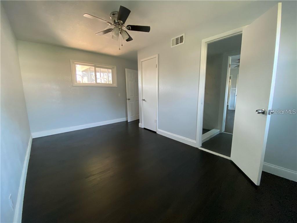 16 Jeff Road Largo, FL 33774 - Photo 8 of 14 an empty room with wooden floor fan and windows