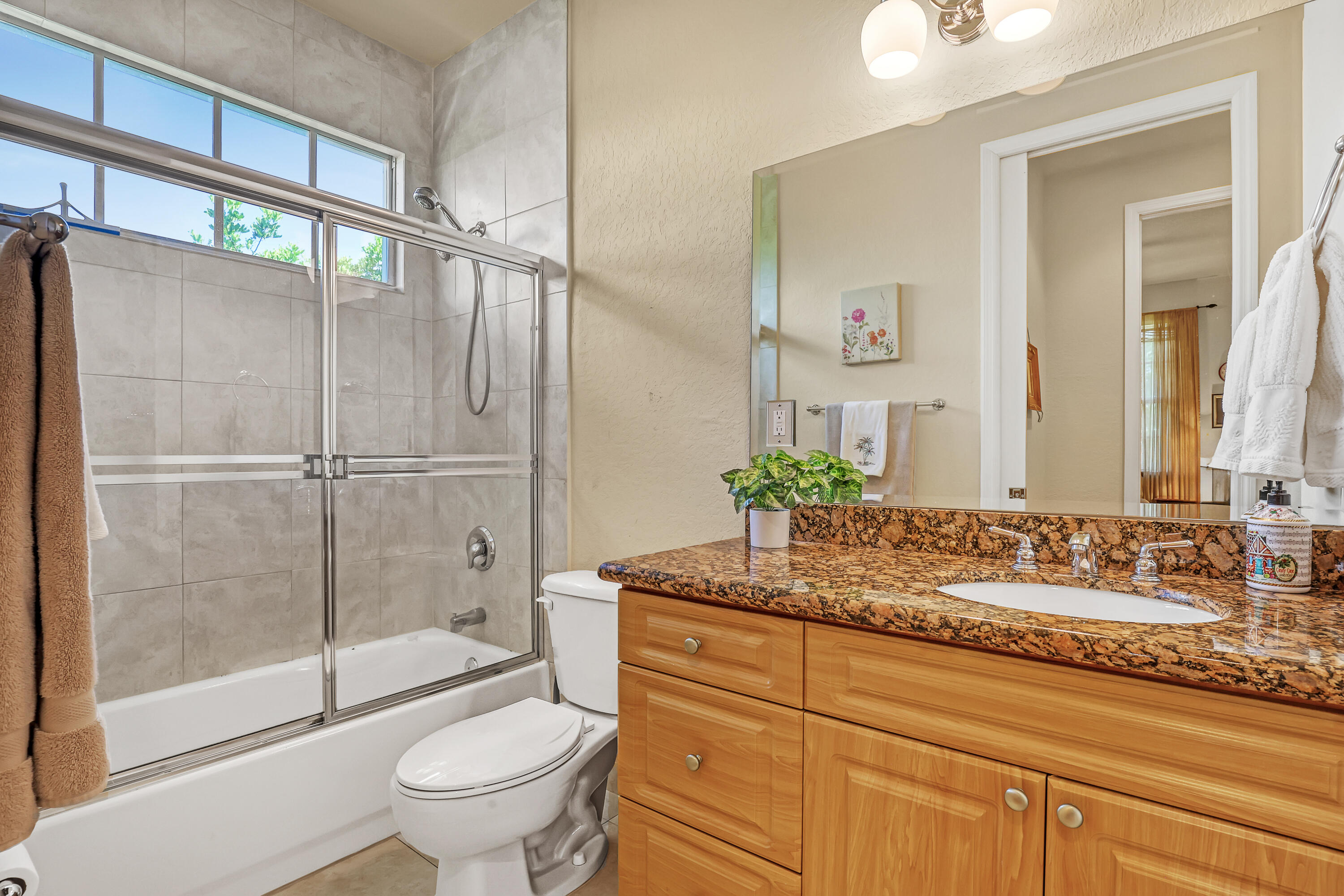 2560 Northeast 11th Street Pompano Beach, FL 33062 - Photo 12 of 18 a bathroom with a granite countertop sink a toilet and shower