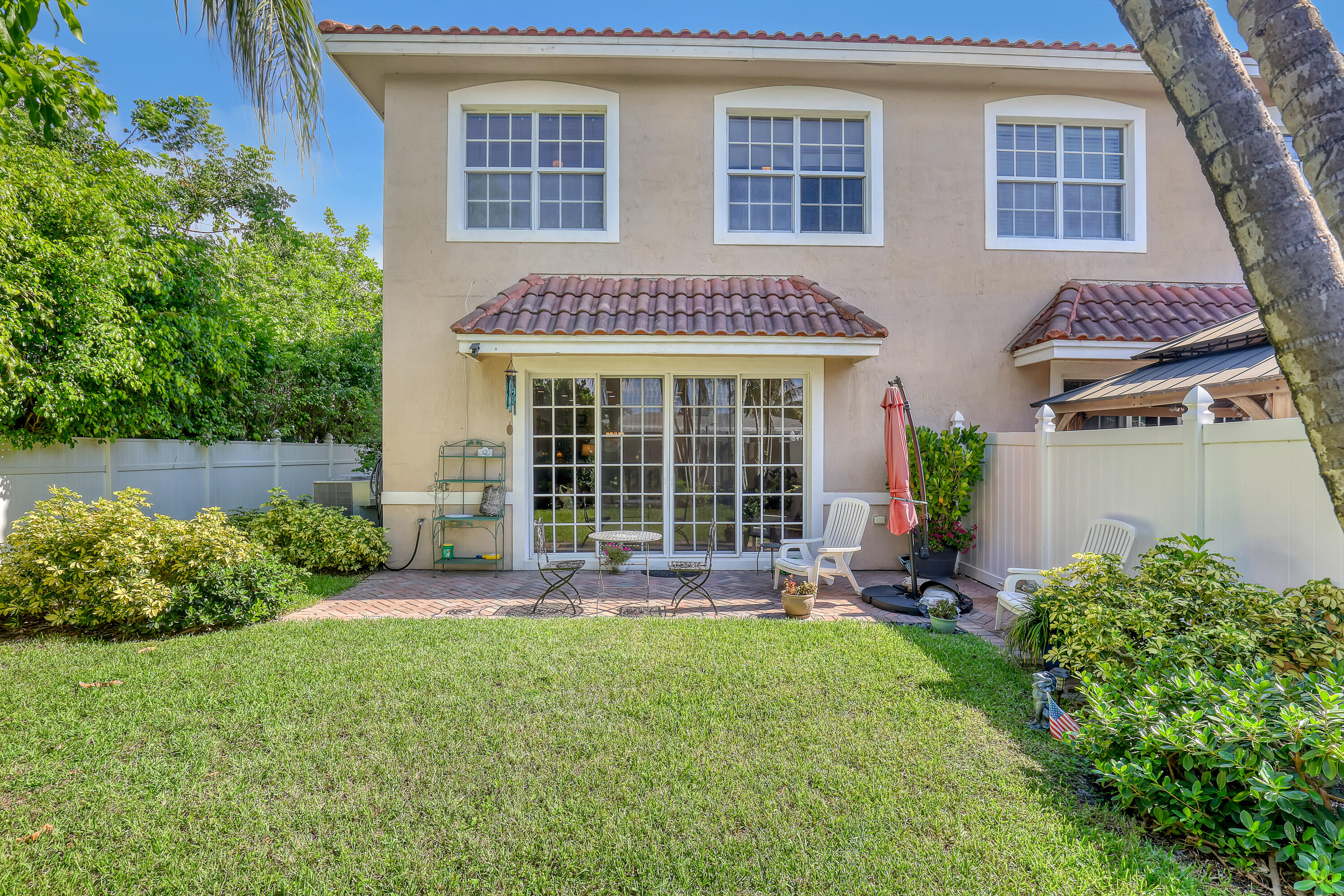 2560 Northeast 11th Street Pompano Beach, FL 33062 - Photo 14 of 18 a front view of a house with a yard and outdoor seating