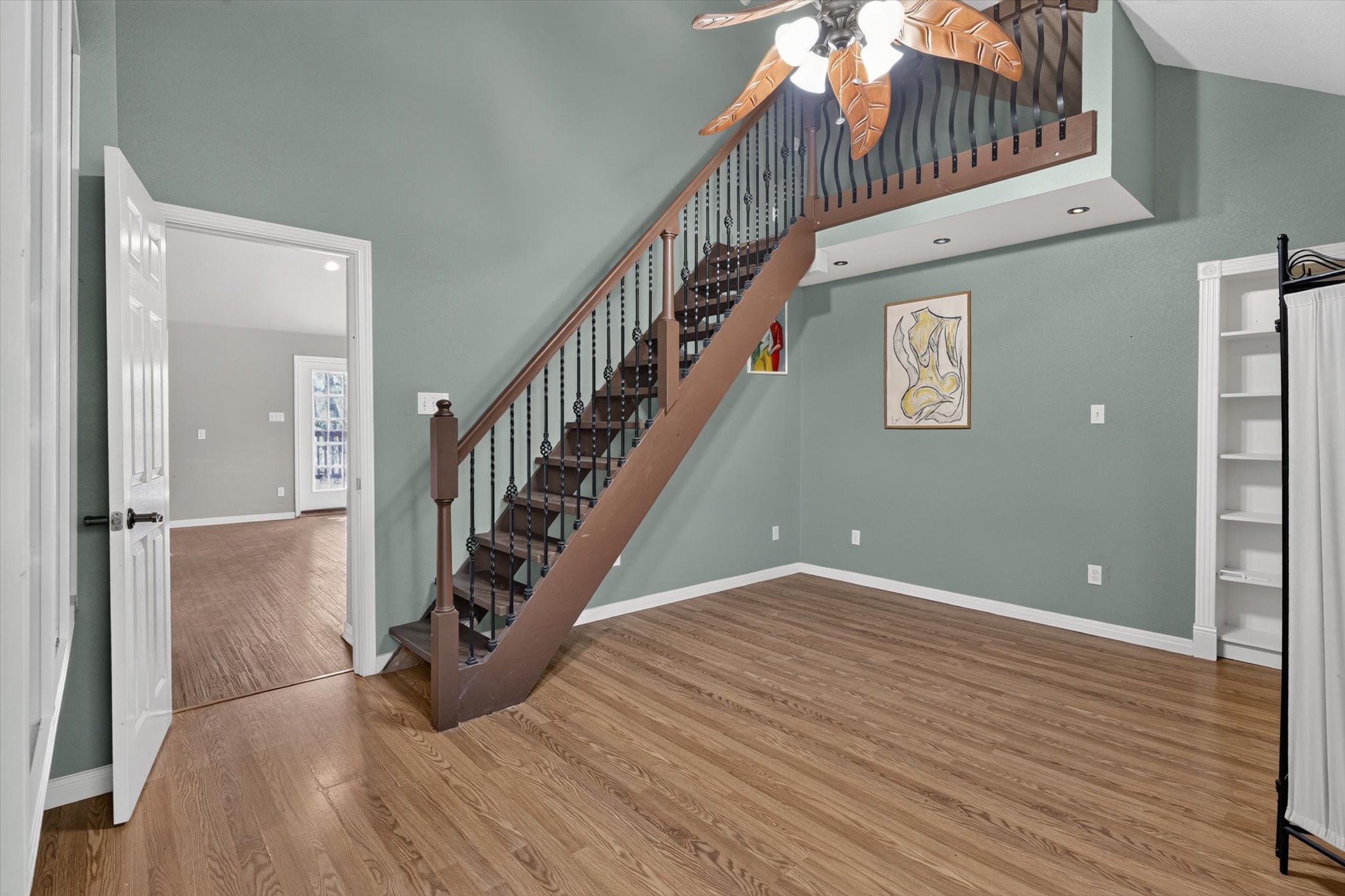 13615 Copperleaf Trail Manchaca, TX 78652 - Photo 24 of 38 A striking staircase with wrought iron balusters ascends gracefully, complemented by richly toned hardwood flooring.